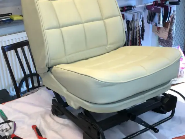 Cream leather seat on a work stand with tools beside it