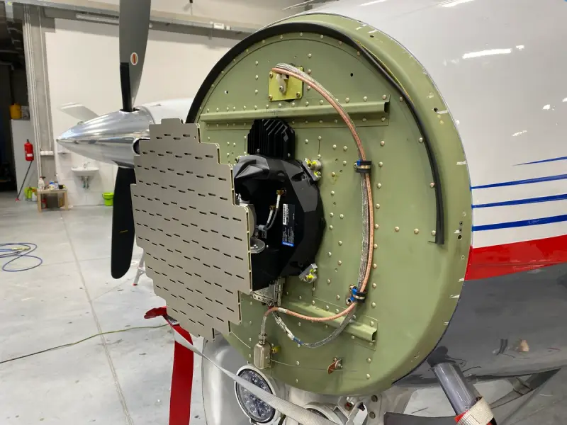 Antenna array panel mounted at the nose of an aircraft in a hangar