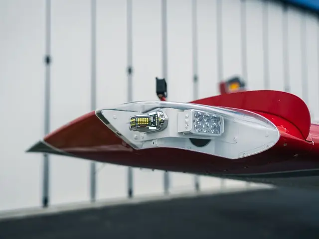 Wingtip navigation light lens on a red wingtip in the hangar