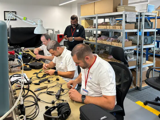 Component repair bench with technicians working on headset cables