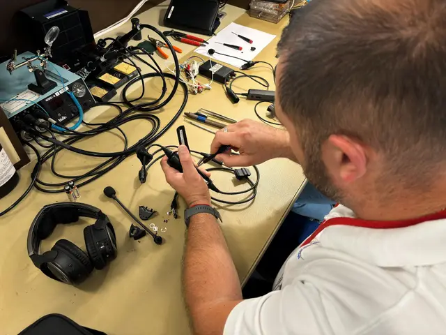 Technician stripping a headset cable at the repair bench