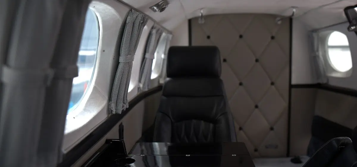Cabin of a Cessna 340 business conversion with quilted sidewalls and black leather seating