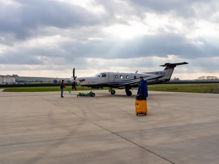 Pilatus PC-12 on the ramp with a technician and a tow bar