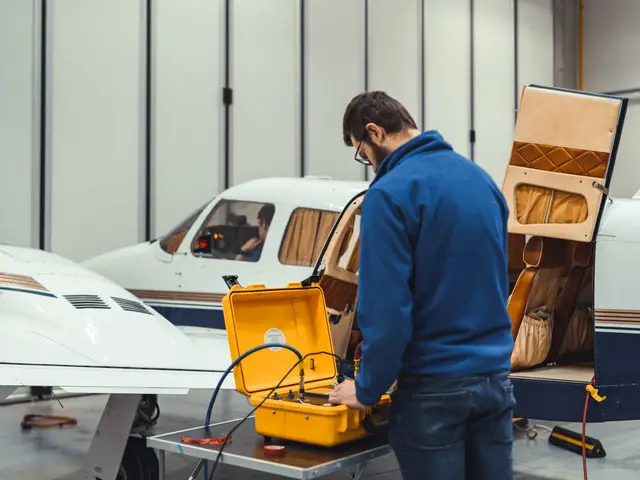 Technician with a yellow test set at the open cabin door of a Piper twin