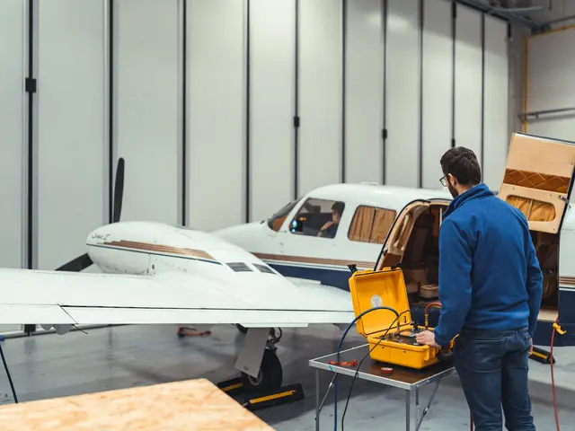 Technician running a pitot-static test set beside a Piper Seneca in the hangar