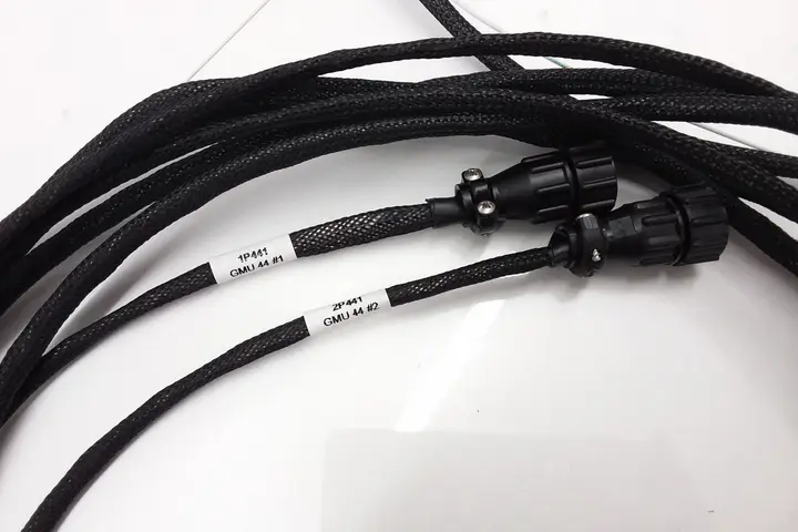 Finished braided wiring harness with labelled connectors on a bench