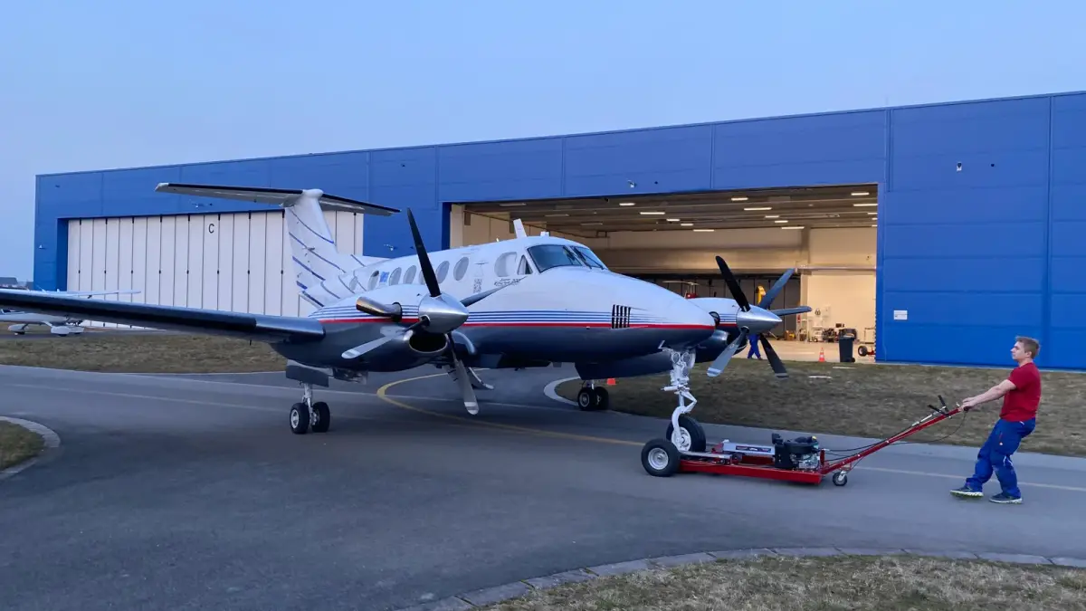 Beechcraft B200 Super King Air being towed out of the hangar