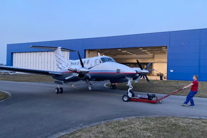 Beechcraft B200 Super King Air being towed out of the hangar
