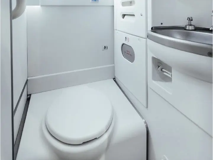 Aircraft lavatory before and after an upgrade with a lit mirror and new worktop
