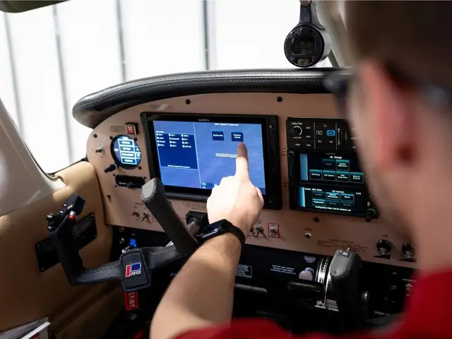 Pilot-side view of a technician operating an avionics display during a software update
