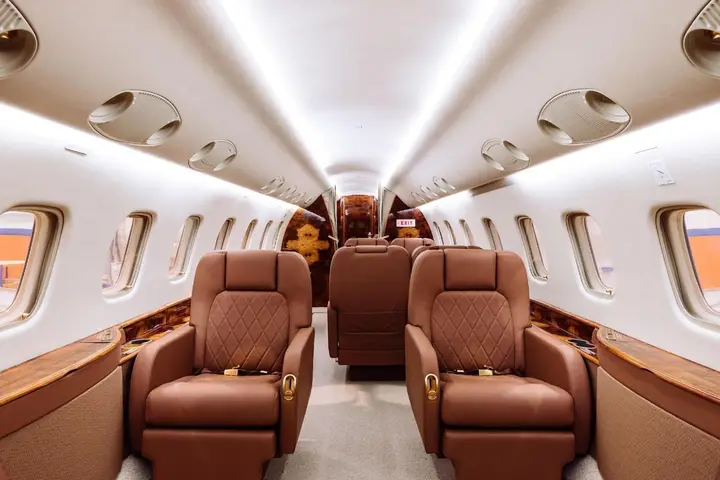 Business jet cabin with club seats and wood trim
