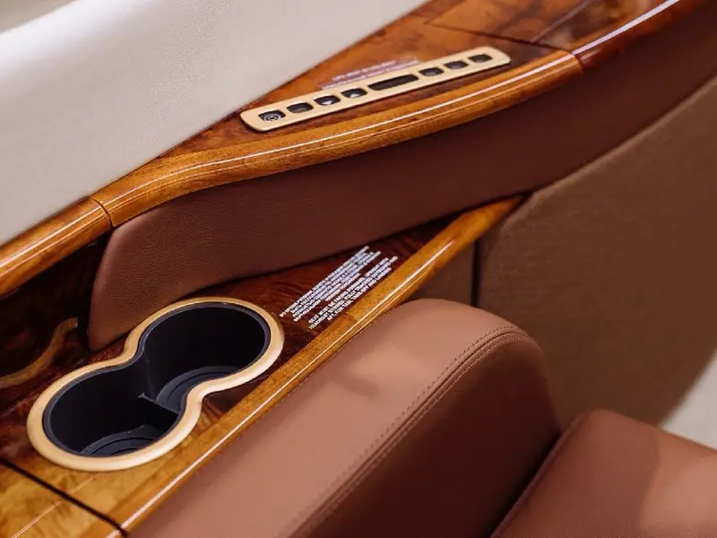 Wood and leather armrest with a cup holder